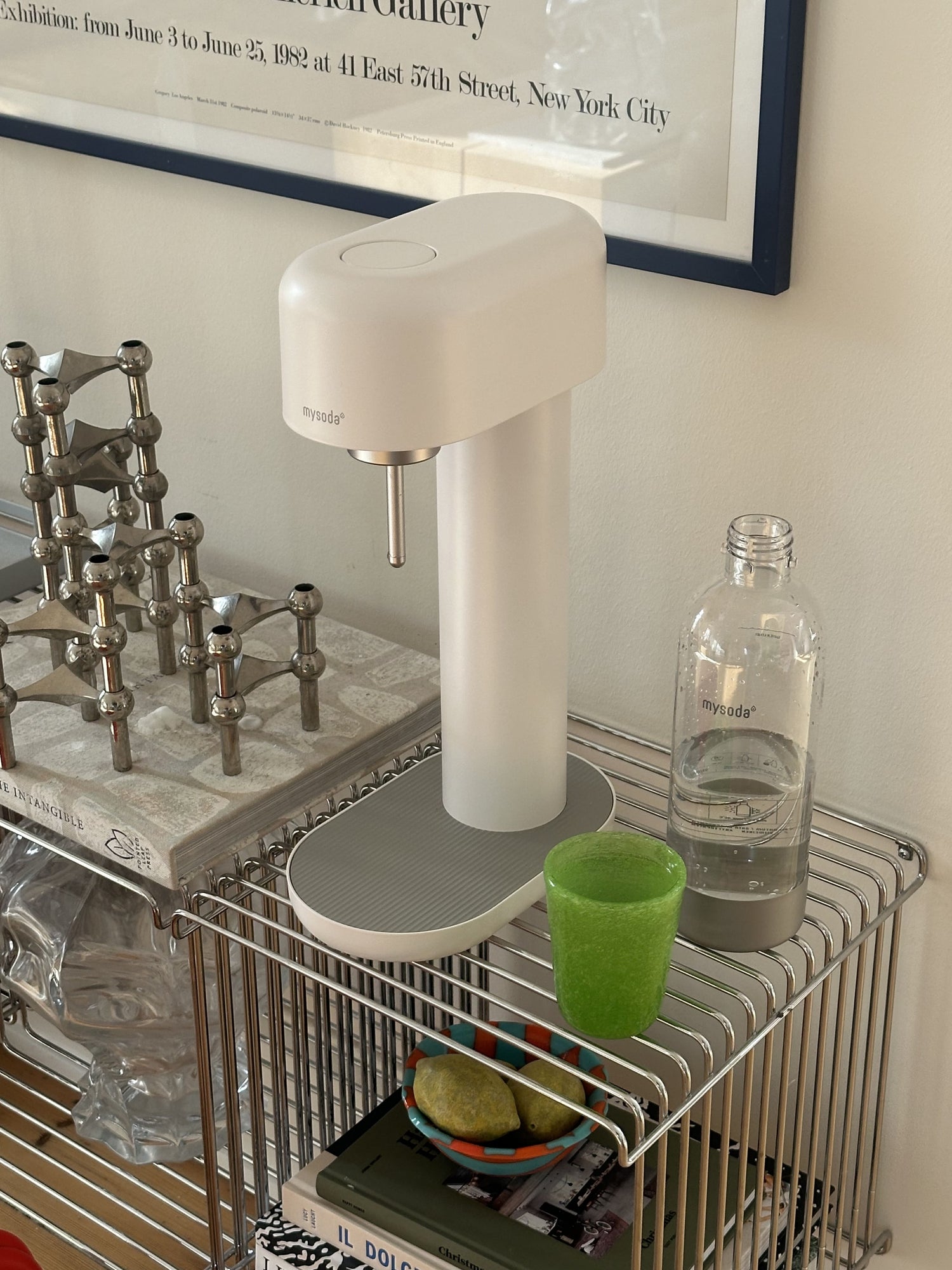 A white-silver ruby 2 soda maker on a modern aluminium shelf next to artsy decor