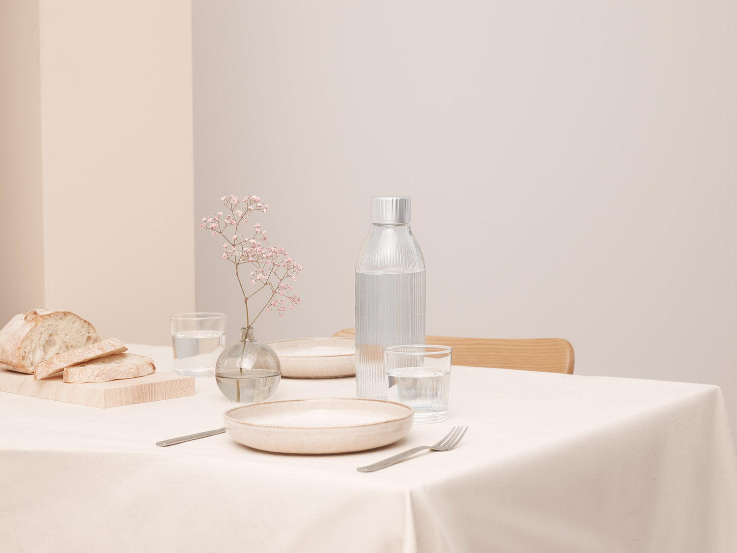 A Mysoda glass bottle for sparkling water makers in an elegant table setting in cream colours