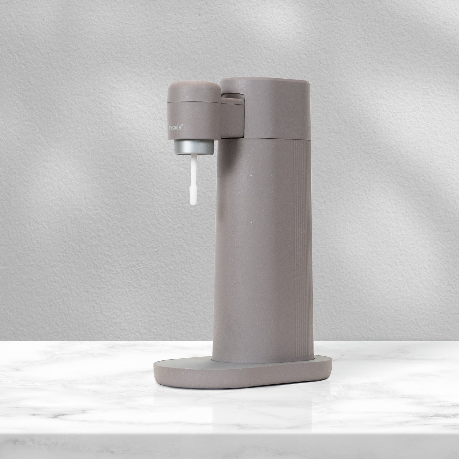 A dove grayish Mysoda Toby sparkling water maker on a marble counter in rays of sunlight