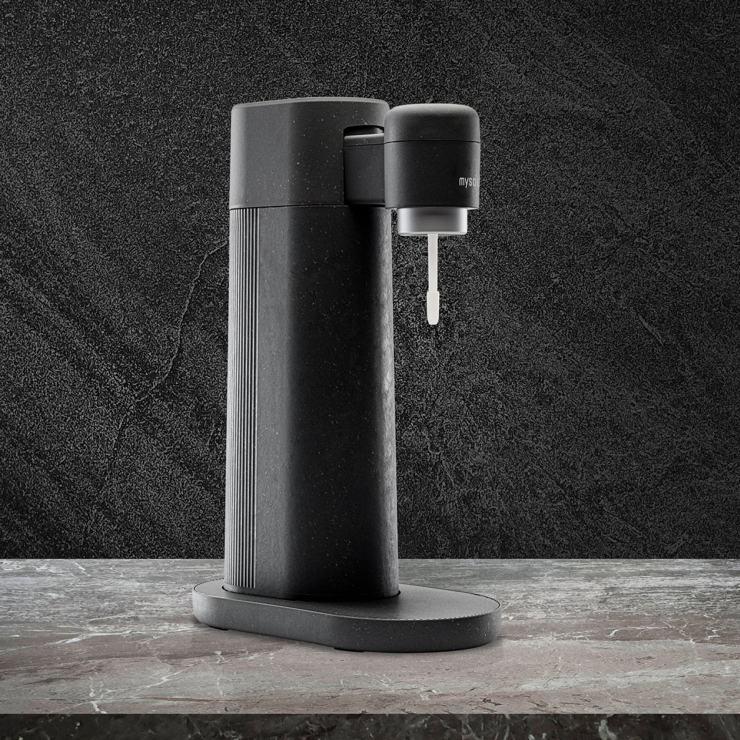 A black Toby sparkling water maker on dark marble counter