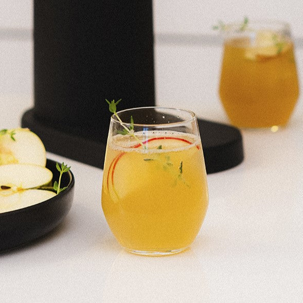 A glass of alcohol-free apple-pear-cocktail decorated with a thyme twig