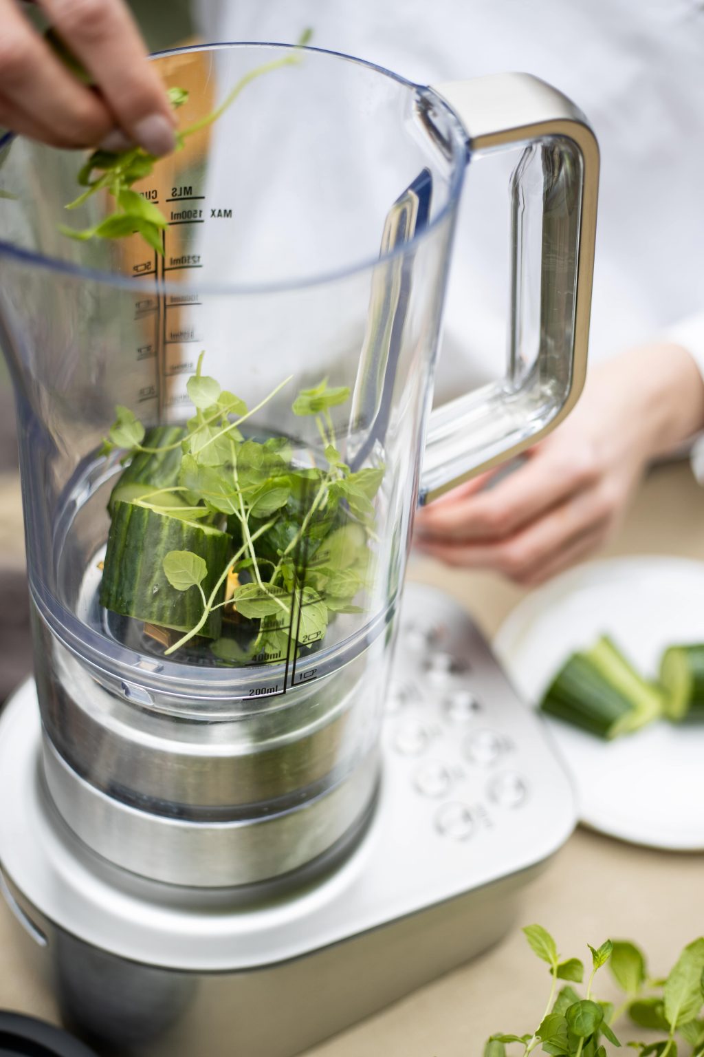 Greens being added to a high-speed blender