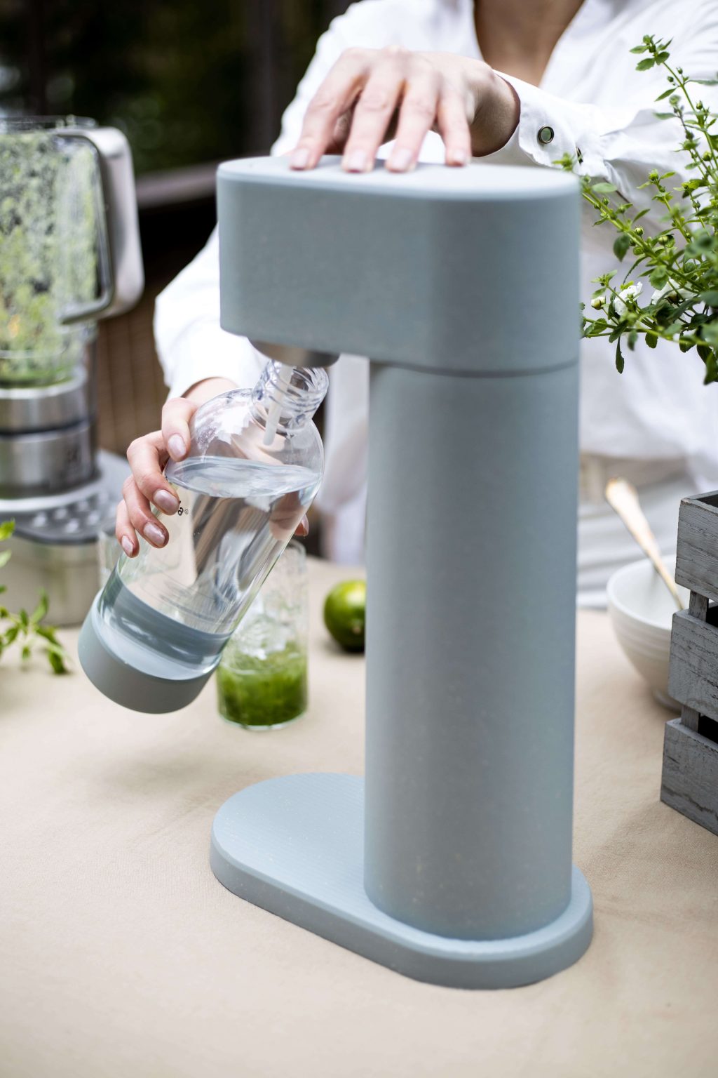 A water bottle being attached to a gray Mysoda Woody sparkling water maker