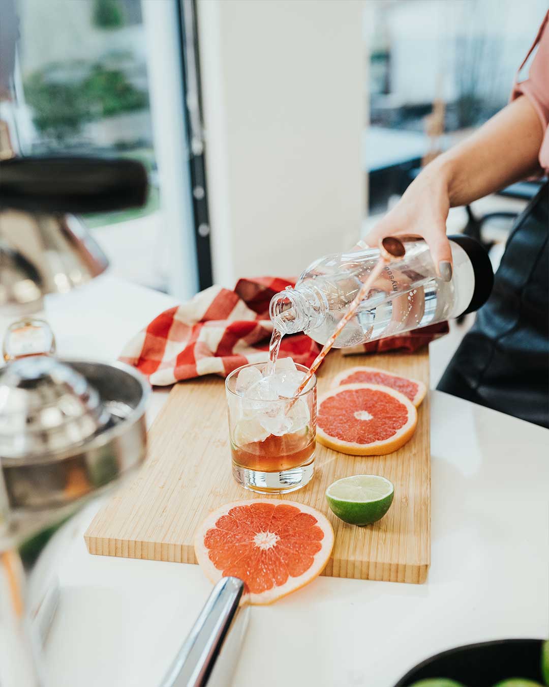Water being added to a glass with ingredients for a quick grapefurit cocktail