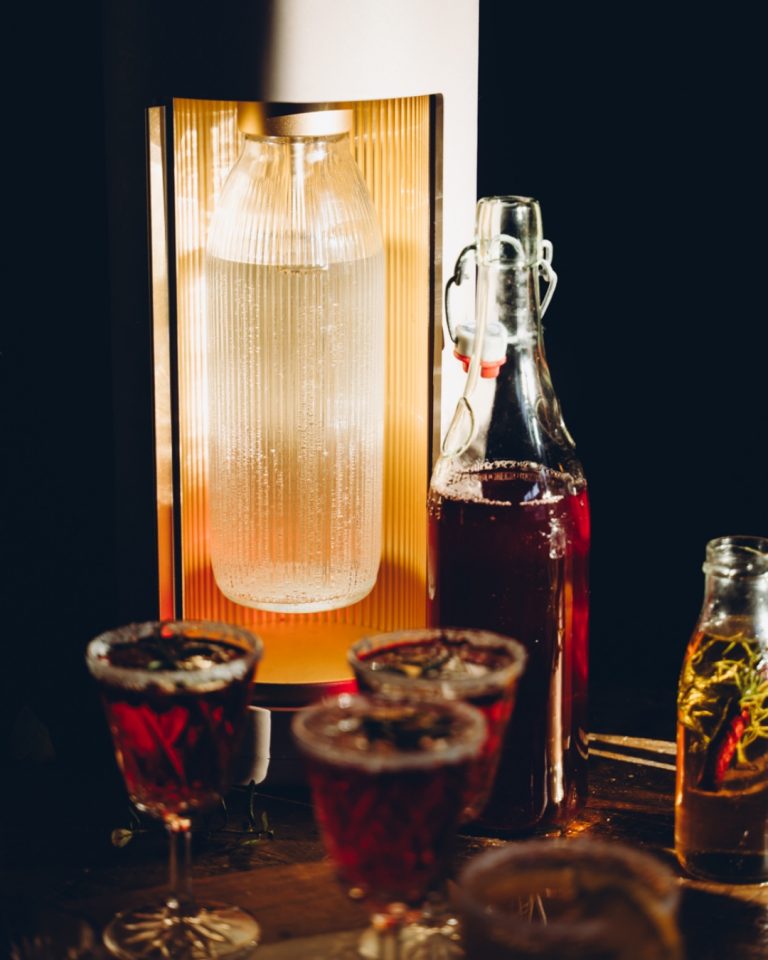 Cranberry-rosmary cocktails and a Mysoda Glassy sparkling water maker in festive lighting