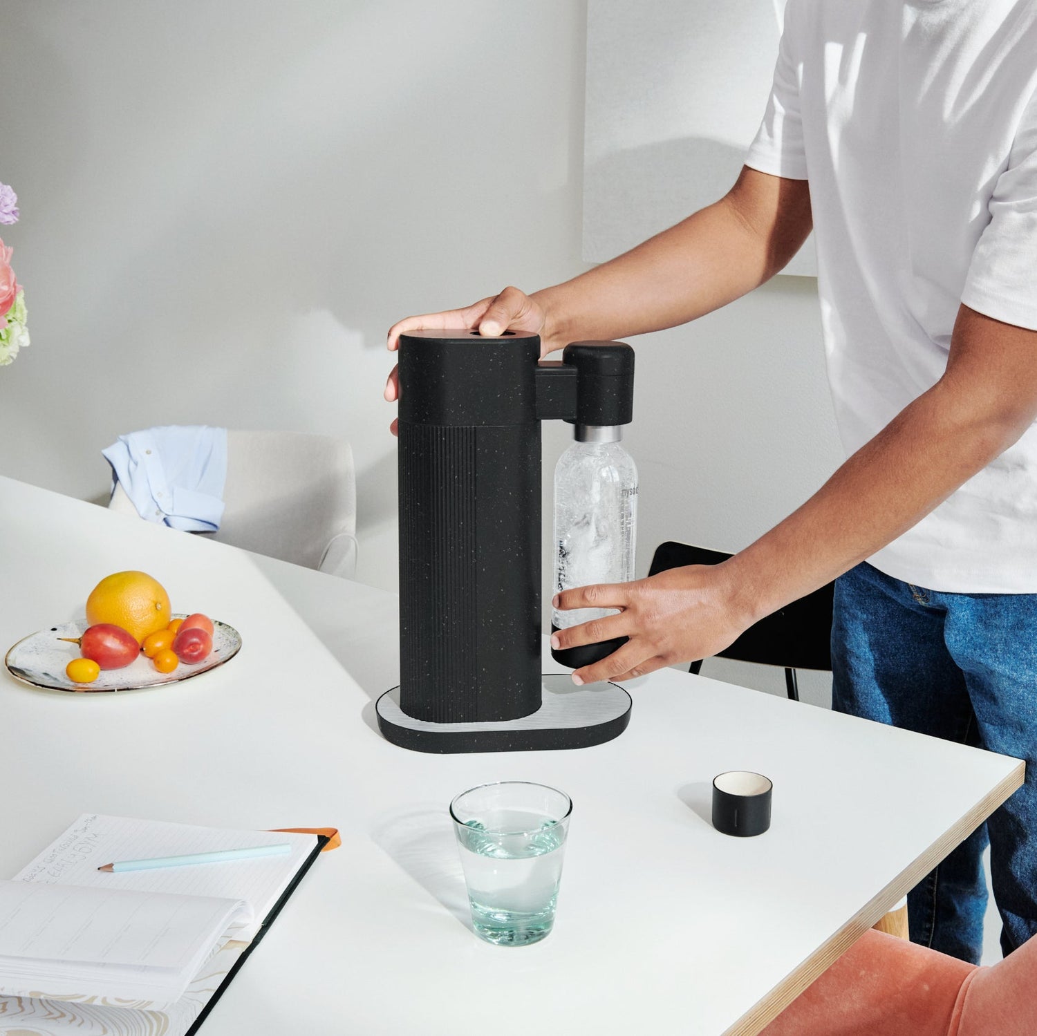 A man making sparkling water using a black Mysoda Toby