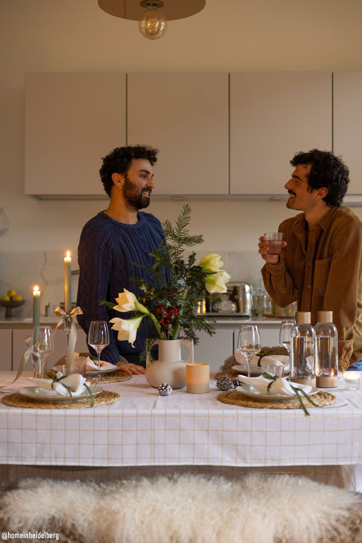 Two men talking at a festive dinner table with elegant winter decoration