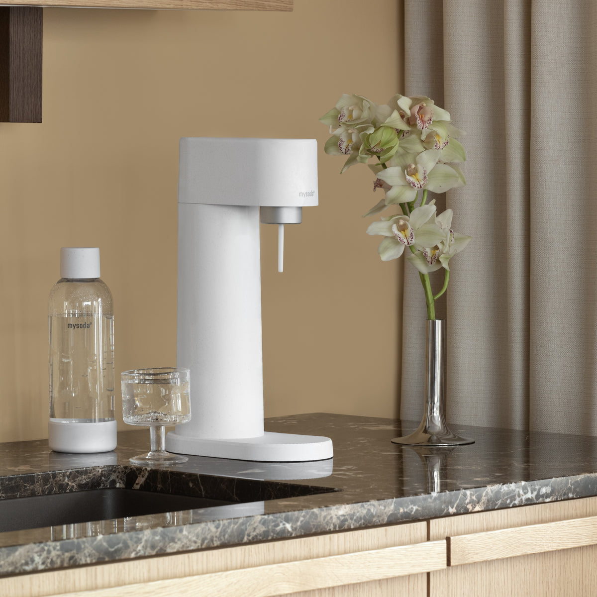 A white Woody sparkling water maker  and water bottle on a kitchen counter