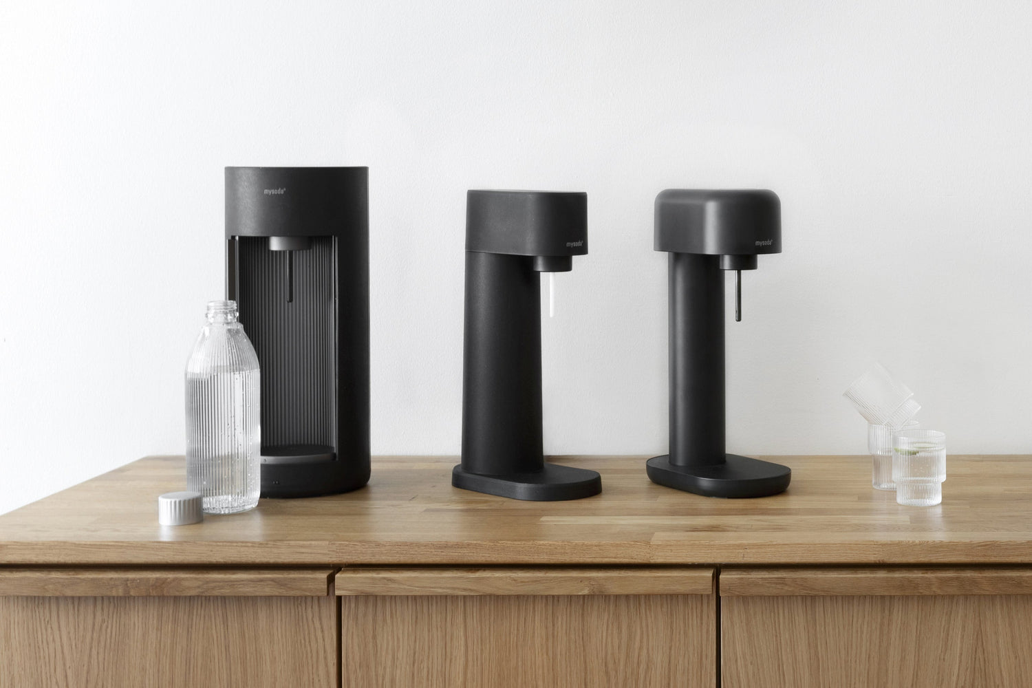 Black Mysoda sparkling water makers Glassy, Woody and Ruby 2 on a wooden kitchen counter