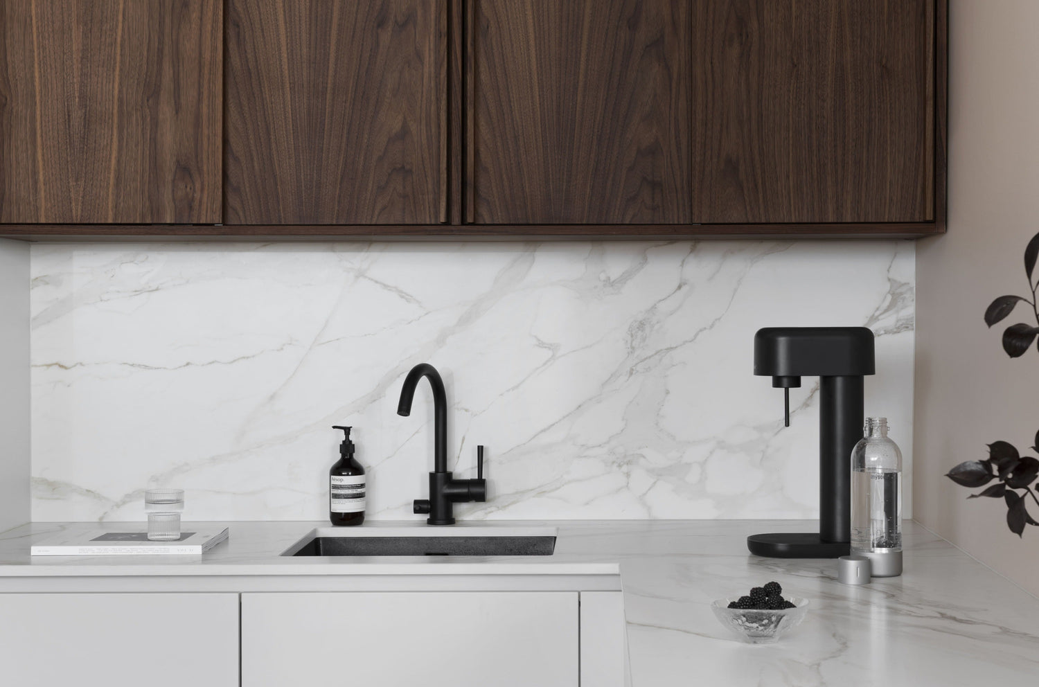 An all black Ruby 2 carbonator in a white marble kitchen counter