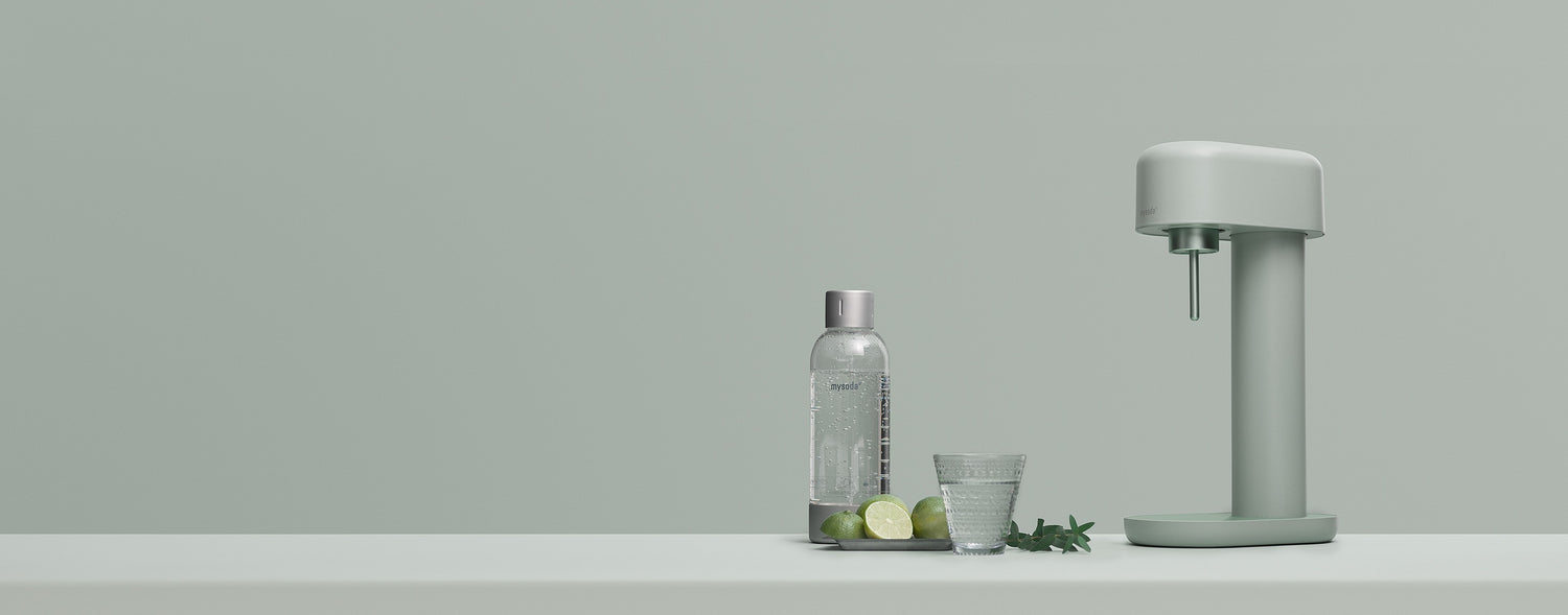 A green Ruby 2 sparkling water maker with water bottle on a matching green background