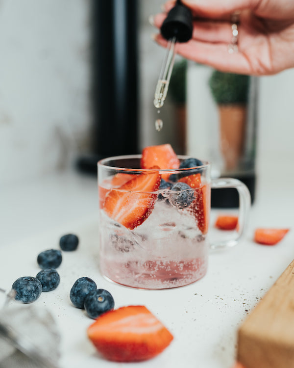 Liquid sweetener being added to a glass of homemade berry iced tea