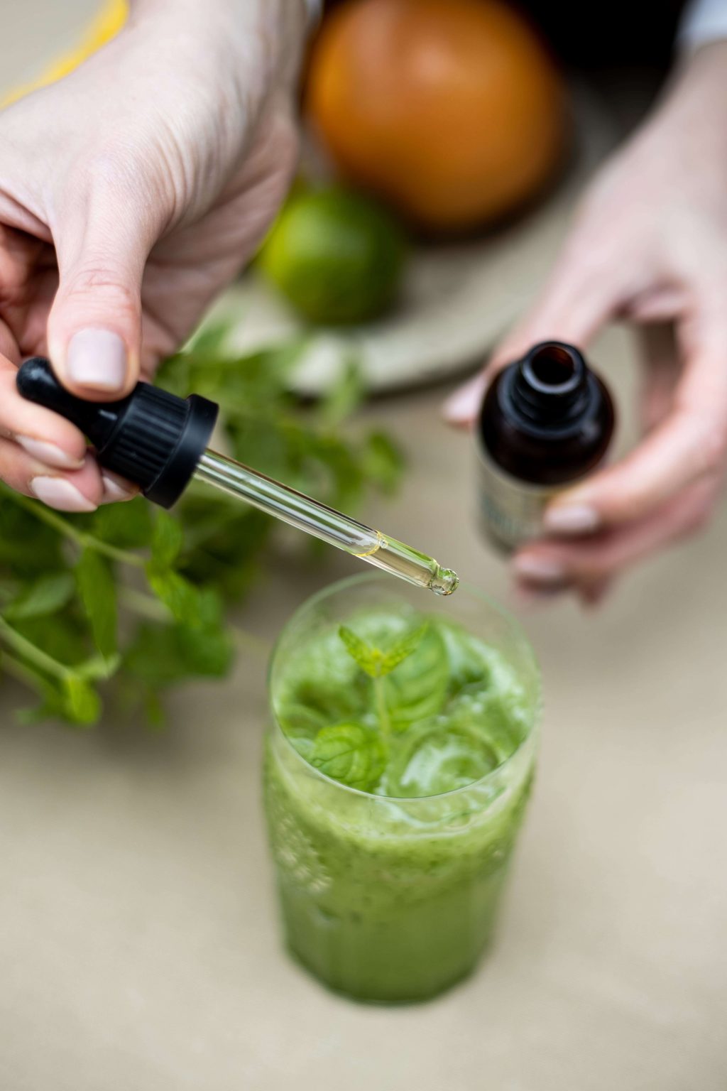 Liquid sweetener being added to a glass of cucumber lime mocktail