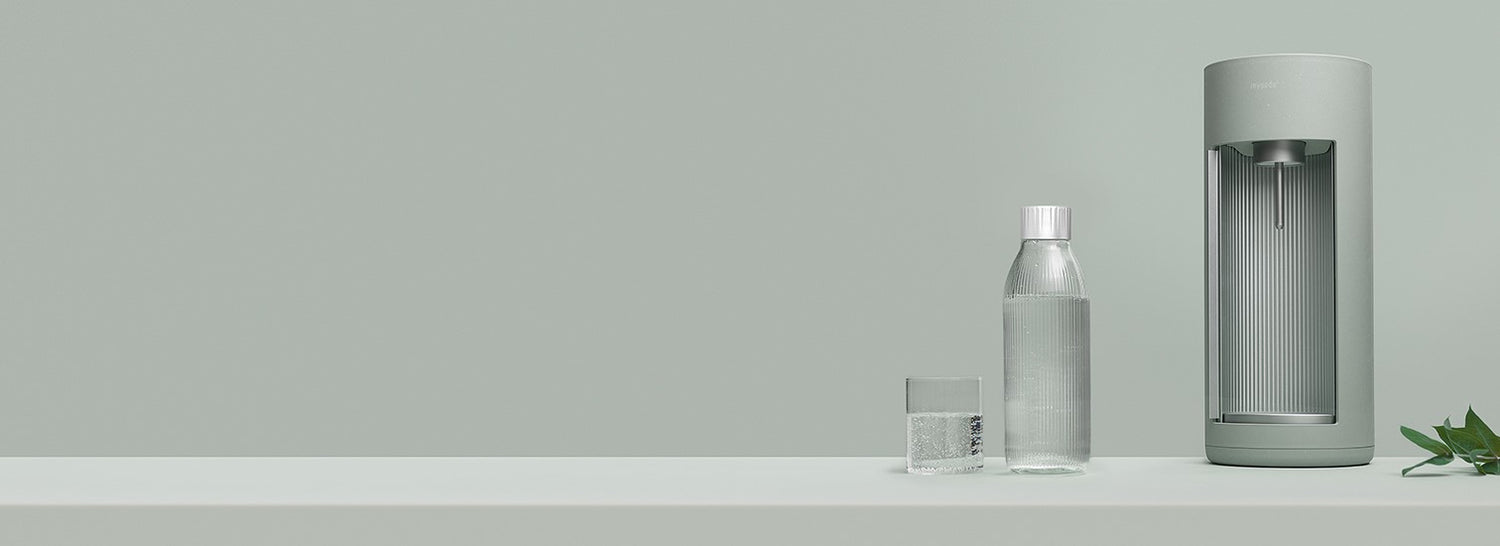 A pigeon-coloured Glassy sparkling water maker and glass bottle on tone-to-tone background