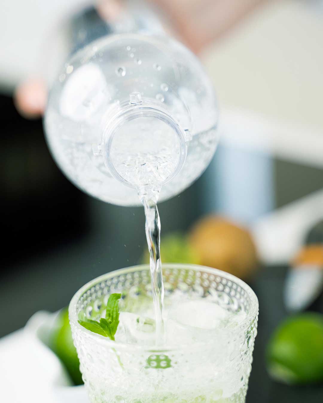 Sparkling water is poured over other ingredients to make a fizzy and tasty kiwi mocktail