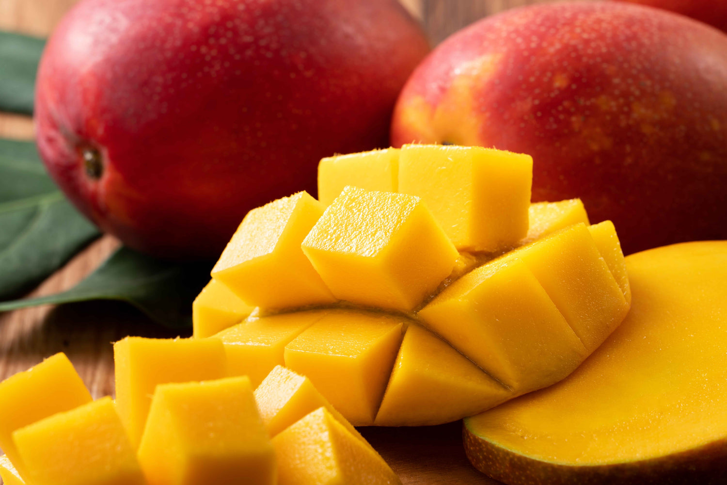 Closeup of mangos, some whole and some cut into cubes