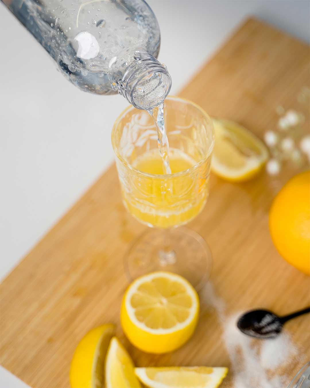 Sparkling water is added to a glass of lemon and orange juice