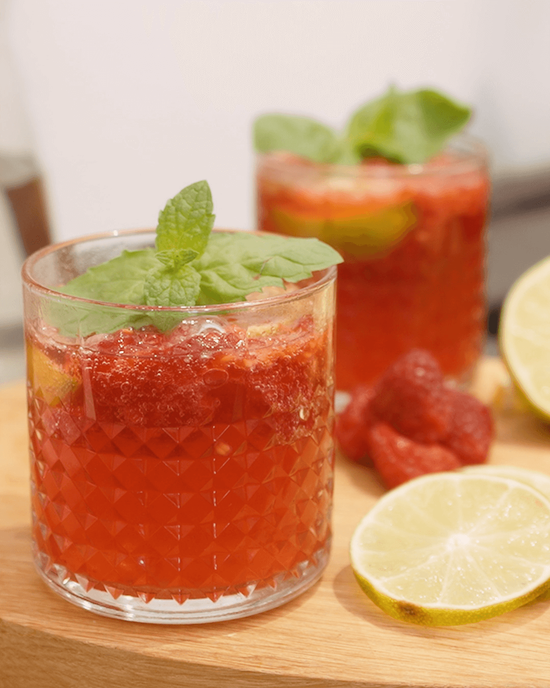 Two glasses of raspberry lime mocktail decorated with mint leaves