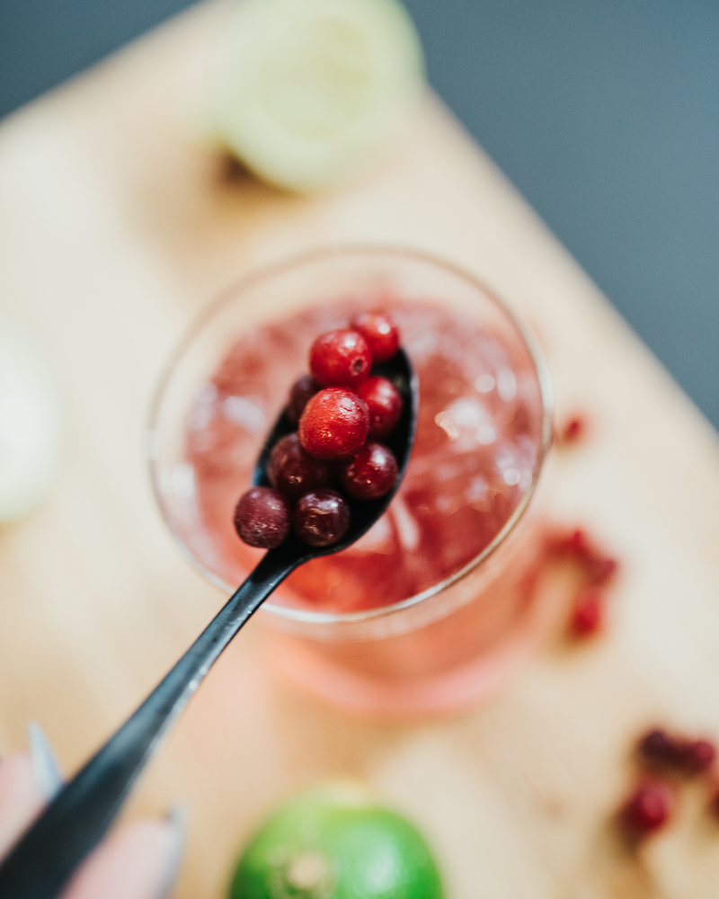 Cranberries werden in den Mocktail gegeben